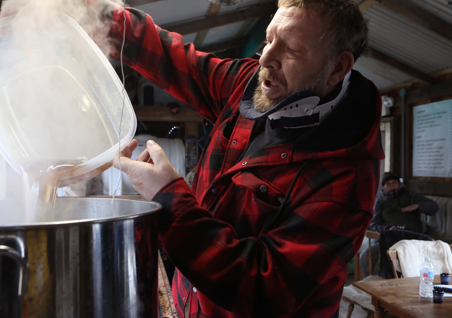 Tim Vieth pours boiled sap into a pot